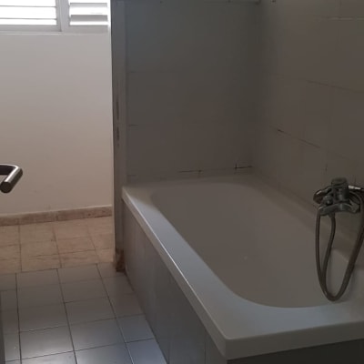 אמבטיה עם אריחים לבנים וברז מתכת