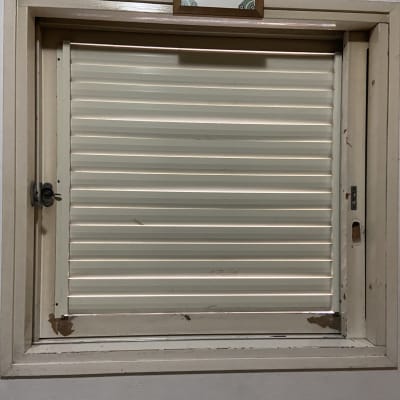 תריס אלומיניום סגור במסגרת חלון עץ ישנה