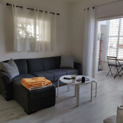 רצפת פרקט בהירה בסלון עם ספה ושולחן