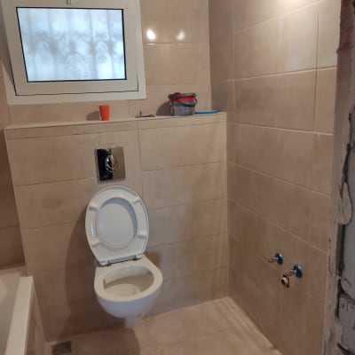 שירותים עם אריחים חדשים, חלון וכלים לשיפוץ