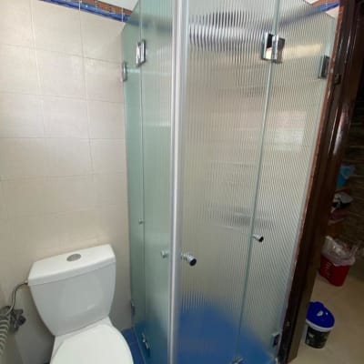 מקלחון זכוכית עם דלתות מתכת בחדר אמבטיה