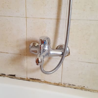 ברז אמבטיה עם צינור מקלחת על קיר קרמיקה