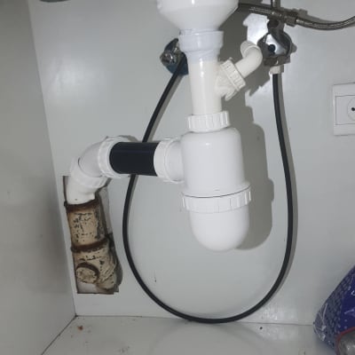 צנרת פלסטיק לבנה מתחת לכיור עם חיבורים