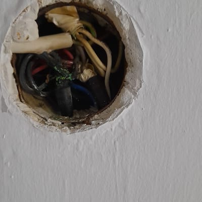 חוטי חשמל חשופים בתוך קיר עגול