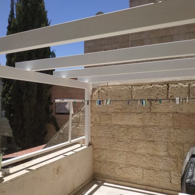 מרפסת עם קורות עץ לבנות וחבל כביסה