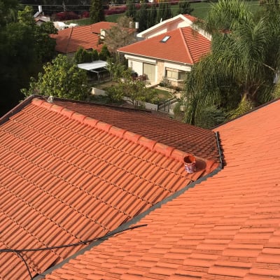 גג רעפים אדום עם דלי צבע על הרכס