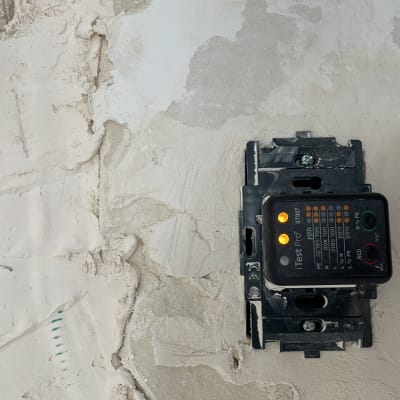 בודק חשמל על קיר עם טיח