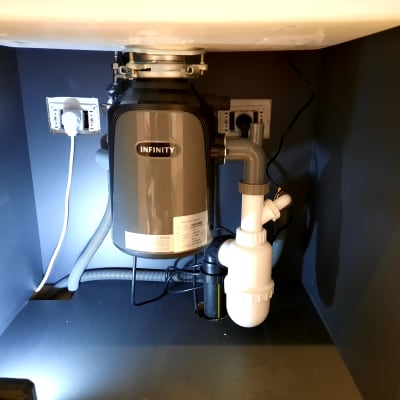 מתקן טוחן אשפה מתחת לכיור עם צנרת פלסטיק