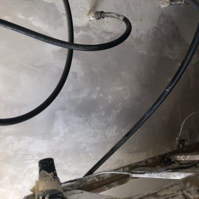 צינורות שחורים על קיר צבוע בלבן