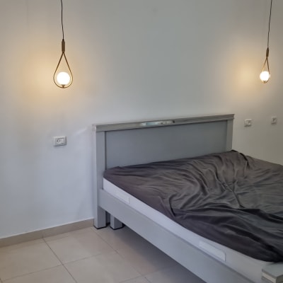 מנורות תלויות על קיר לבן בחדר שינה