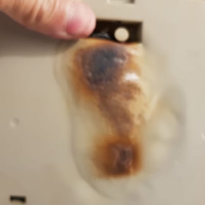 חלק פלסטיק שרוף עם סימני חום כהים