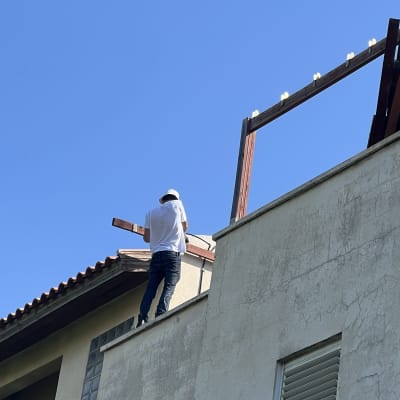 אדם עובד על מבנה עם מסגרת אלומיניום