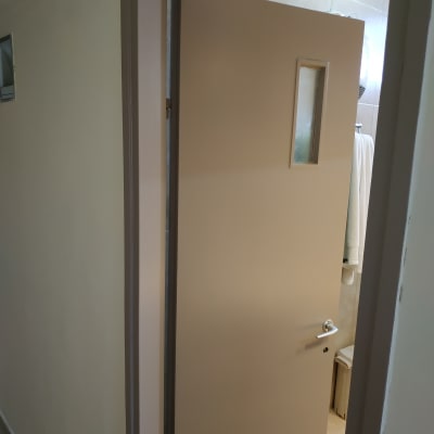 דלת צבועה בצבע בהיר עם חלון קטן