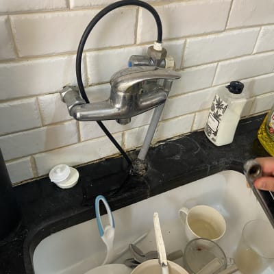 ברז מטבח עם צינור שחור וכלים בכיור