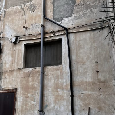 קיר עם צינורות פלסטיק וחלון קטן