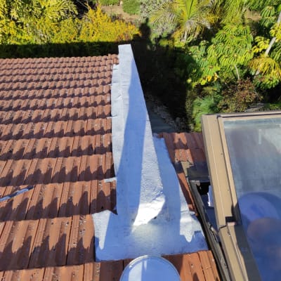 איטום גג עם חומר לבן על רעפים חומים