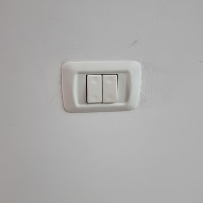 מתג חשמל כפול על קיר לבן