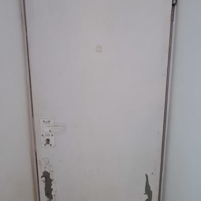 דלת לבנה עם קילופי צבע ופגמים