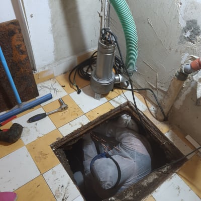 אדם בחליפת מגן עובד בבור עם צינור ירוק