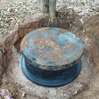 מכסה ביוב עגול מכוסה באדמה
