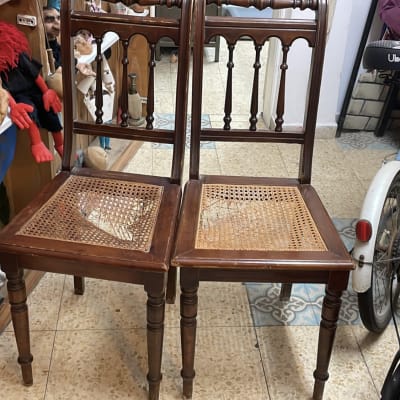 שני כיסאות עץ עם מושב קלוע, ללא ריפוד.