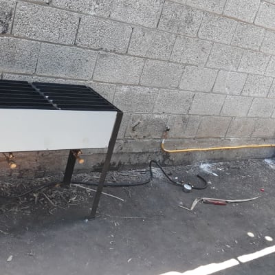 גריל גז עם בלוני גז וחיבורים על רצפה