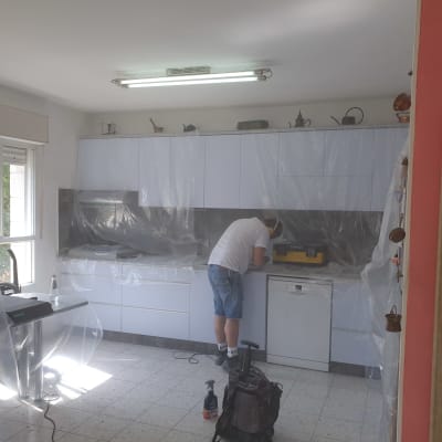 אדם עובד על משטח שיש במטבח מכוסה בניילון