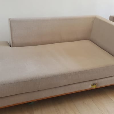 ספה בהירה עם רגלי עץ על רצפת עץ