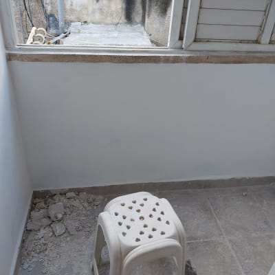 שברי טיח על הרצפה ליד שרפרף פלסטיק