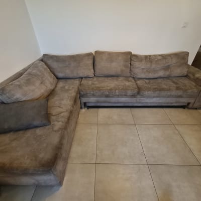 ספה פינתית מלוכלכת על רצפת אריחים