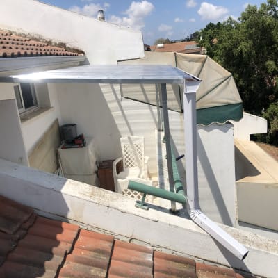 גג עם רעפים אדומים ומרזב לבן