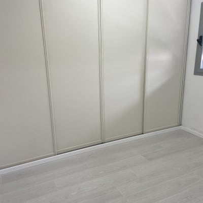 רצפת פרקט עץ בהירה בחדר עם קיר לבן