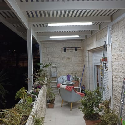 עציצים על מרפסת עם סולם וכיסא