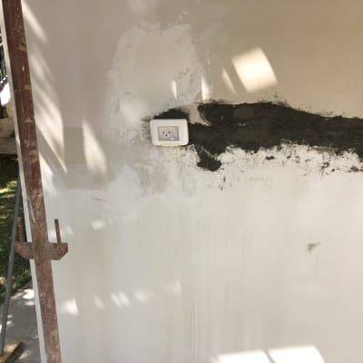 שקע חשמל מותקן על קיר עם טיח רטוב