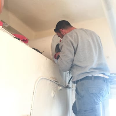 אדם מתקין דוד שמש על קיר פנימי