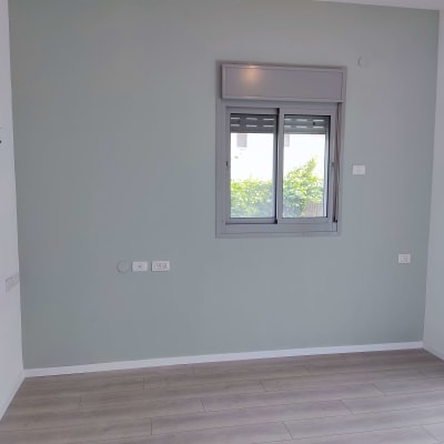 קיר צבוע בצבע ירוק בהיר עם חלון קטן