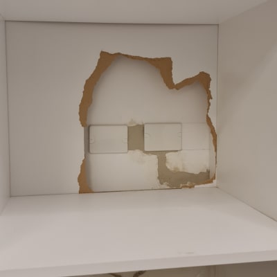 קיר עם חור וארון חשמל חשוף