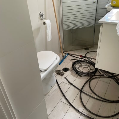 כבלים וכלי עבודה של אינסטלטור בחדר אמבטיה