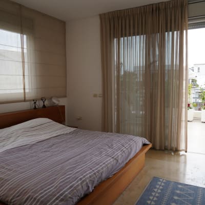 חדר שינה מסודר עם וילונות פתוחים