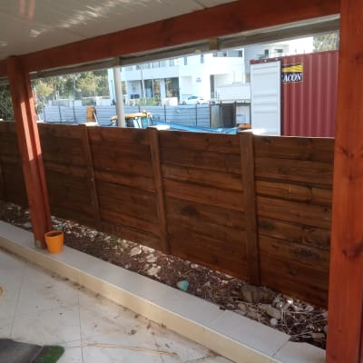 גדר עץ חומה עם עמודי תמיכה אדומים