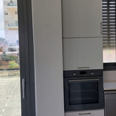 קיר צבוע בלבן ליד חלון ודלת אפורה