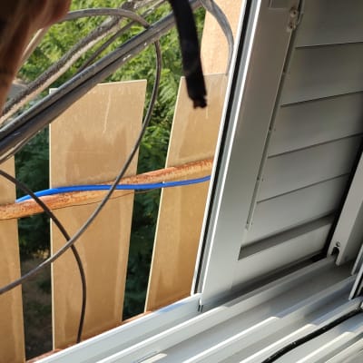 כבל שחור מחובר למערכת סולרית מחוץ לחלון