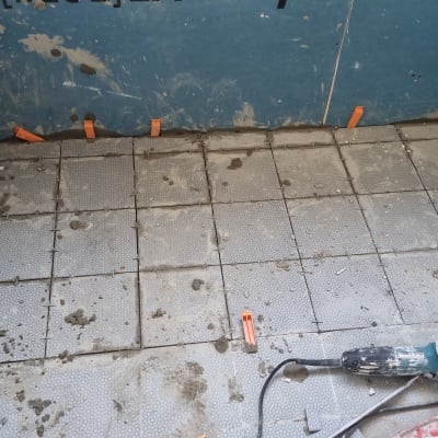 רצפה עם אריחים, כלי עבודה וצינורות חשופים