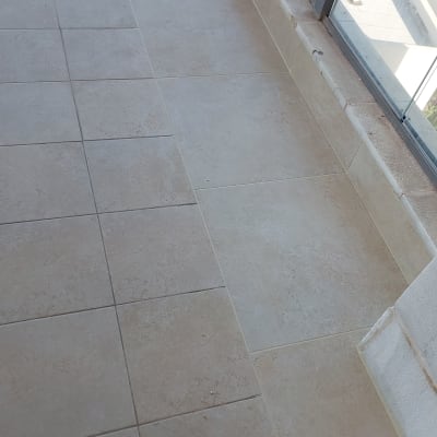 מרפסת עם ריצוף חדש ומעקה זכוכית