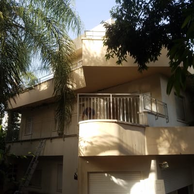 מרפסת עם מעקה מתכת, סולם נשען על הקיר