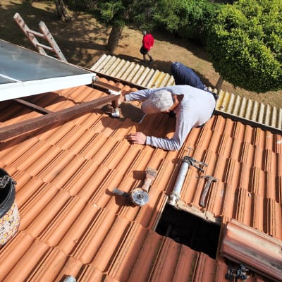 עובד על גג רעפים עם כלים וחור פתוח