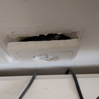 שקע חשמל בקיר עם חוטי חשמל חשופים