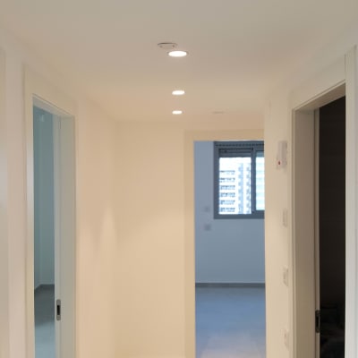 מסדרון עם קירות גבס ותאורה שקועה בתקרה