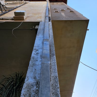 צינור מתכת על קיר בניין מתחת לגג