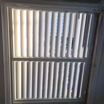 חלון עם תריסי אלומיניום פתוחים למחצה